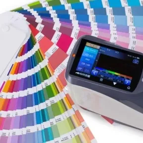 Colour swatch fan and a spectrophotometer on a bench