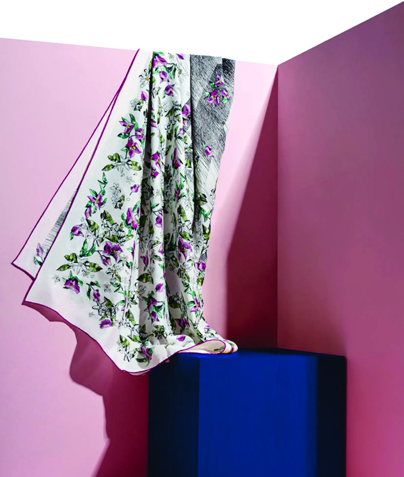 Printed floral silk scarf draped over a blue block